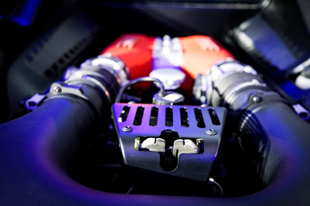 Close-up of a car engine with prominent red components, metal pipes, and various mechanical parts—a prime example of skilled Automotive Aftermarket Management.