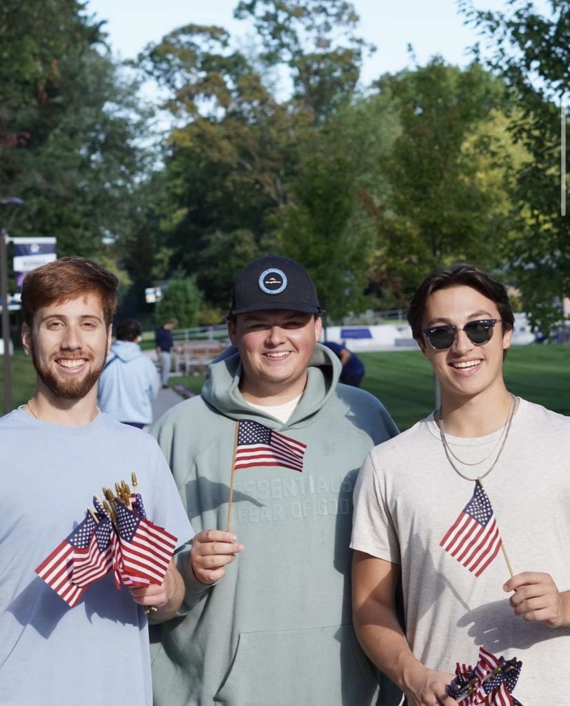 Three Kappa Sigma brothers holding American flags