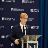 A person in a suit speaks at a podium with a microphone, emphasizing the importance of insurance risk management. The background displays "Northwood University" repeatedly.