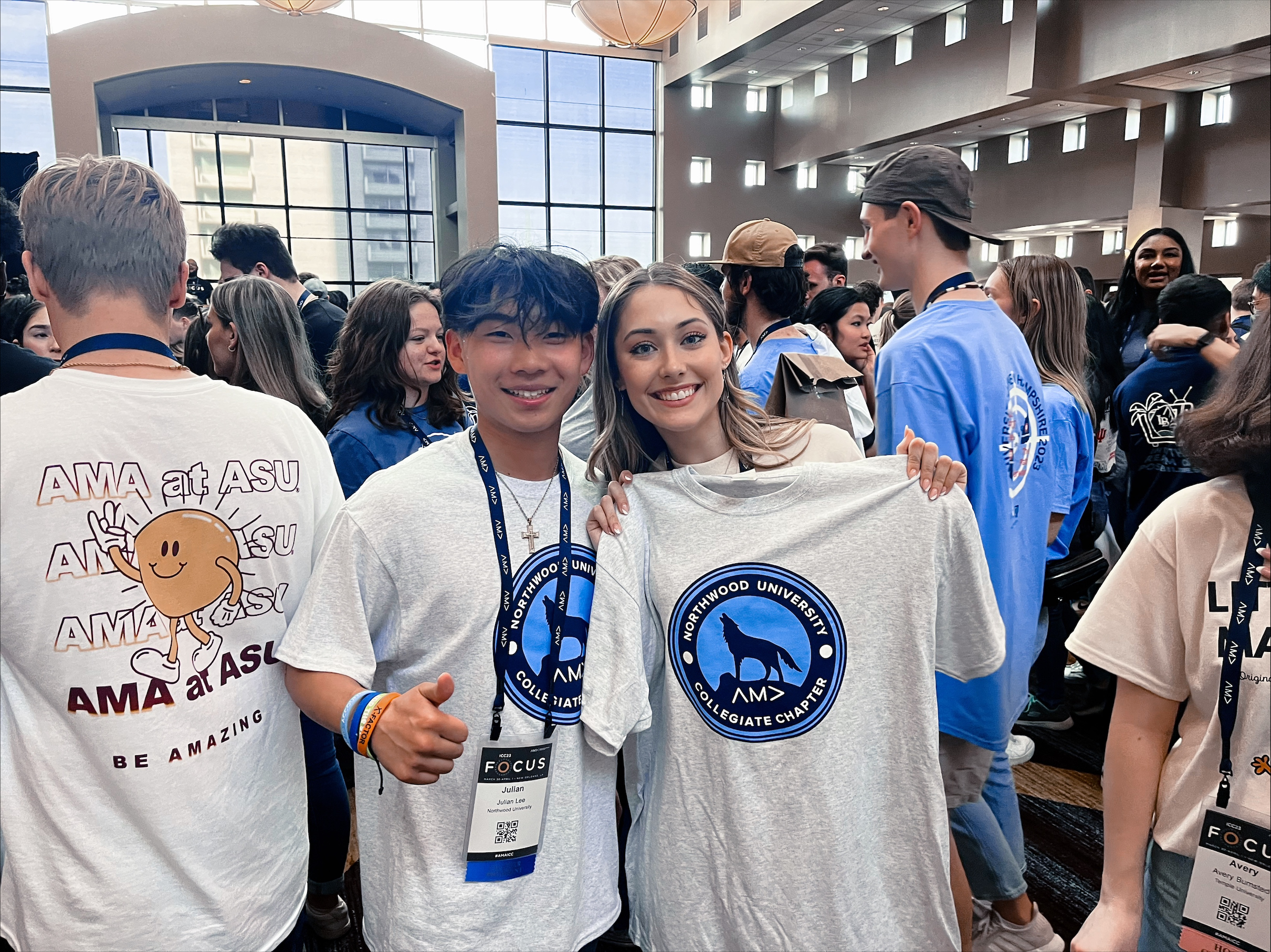 American Marketing Association students holding up t-shirts at a conference