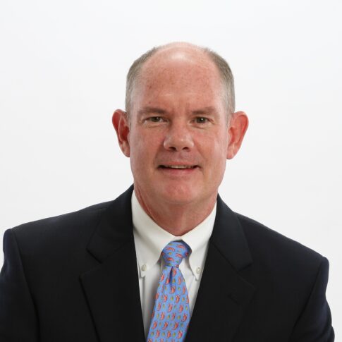 Man in a suit and tie against a plain white background.