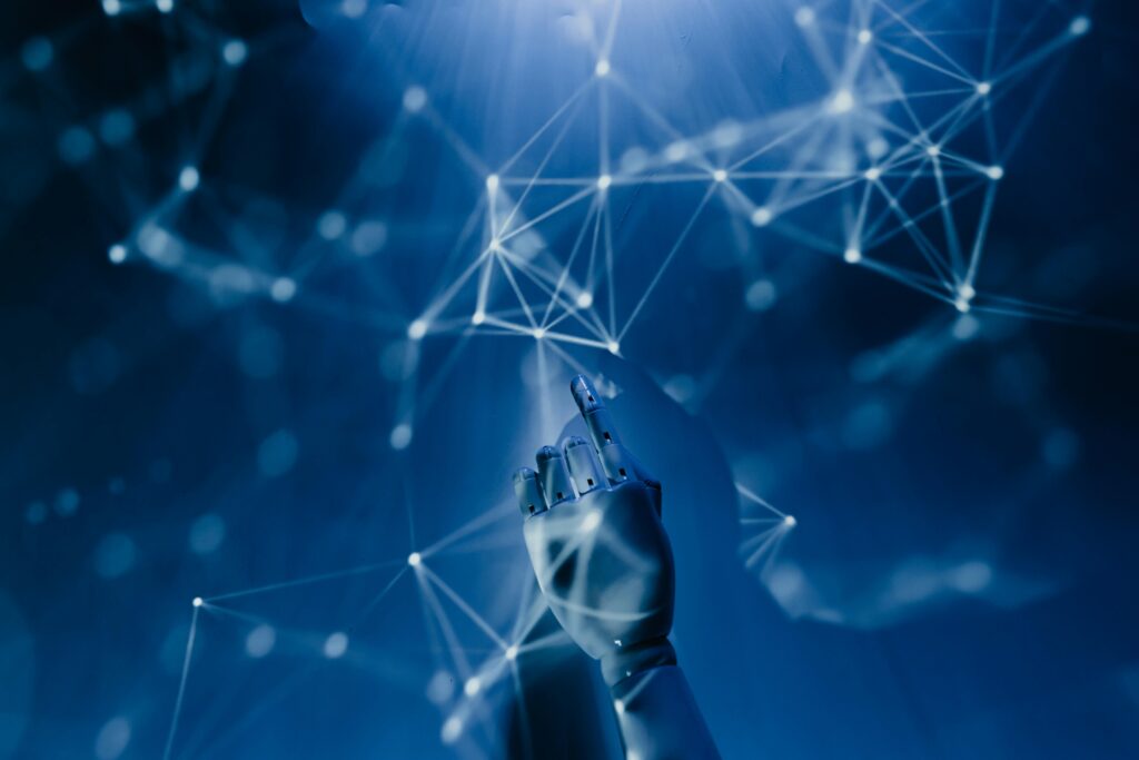 A robotic hand points toward a digital network of connected nodes and lines, set against a blue, futuristic background, symbolizing the advanced connectivity enabled by SAP Programs.