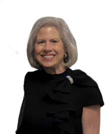 A woman with short gray hair, wearing a black top with ruffle details and a brooch, stands smiling against a plain white background, embodying the elegance celebrated by the Northwood's Distinguished Women Awards.