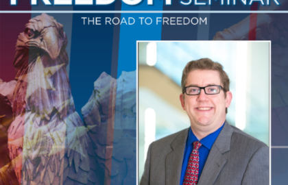 A man in a suit and red tie smiles in front of a blurred background. Text reads "2025-2026 Freedom Seminar: The Road to Freedom" and "Northwood University" with a bird statue in the background.