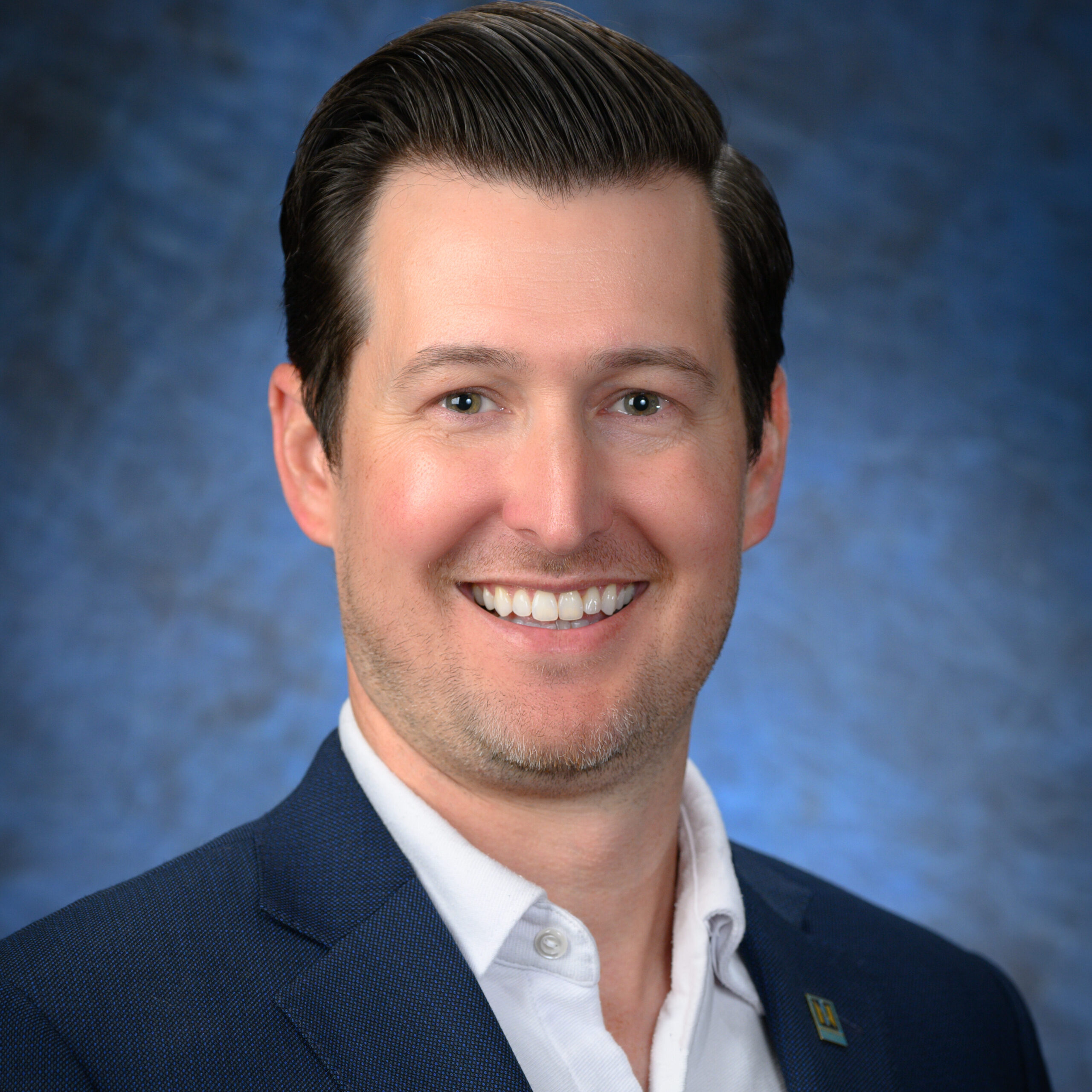 A man in a suit smiling, embodying the confidence and professionalism of Northwood's Central Leadership.