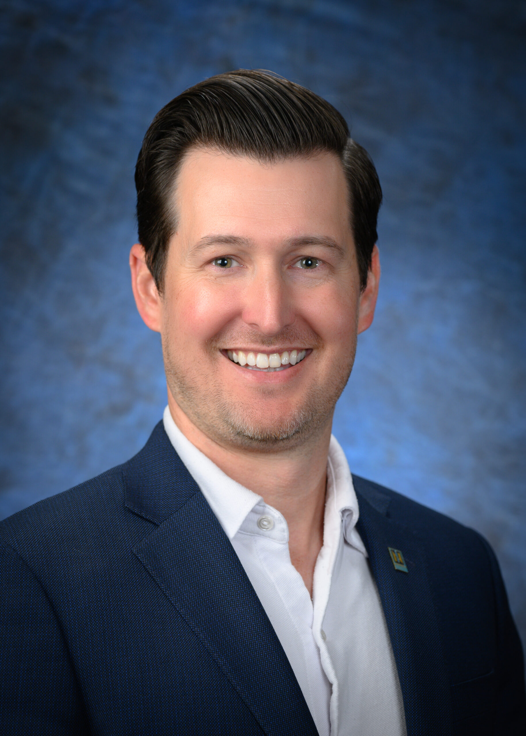 A man in a suit smiling, embodying the confidence and professionalism of Northwood's Central Leadership.