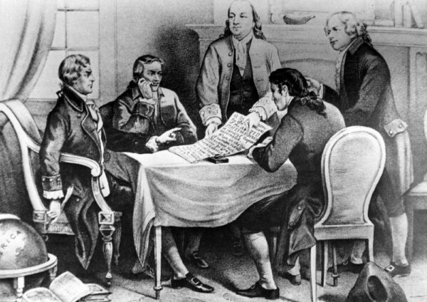 Five men in 18th-century attire gather around a table, examining a large document that will shape the future, in a historical, black-and-white illustration.
