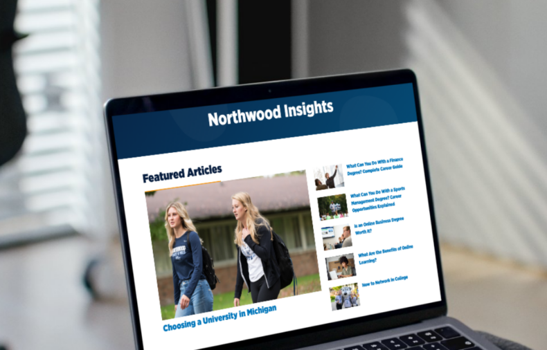 A person uses a laptop displaying a website called "Northwood Insights," featuring articles and a main image of two people walking outdoors.