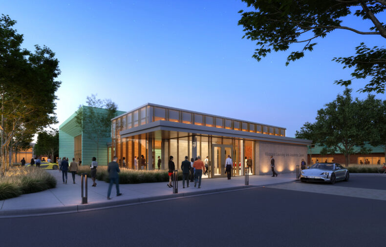 People stand and walk near a modern, well-lit building with large windows at dusk; a car is parked nearby and trees line the surrounding area, highlighting this impressive new rendering of the Northwood University academic facility.