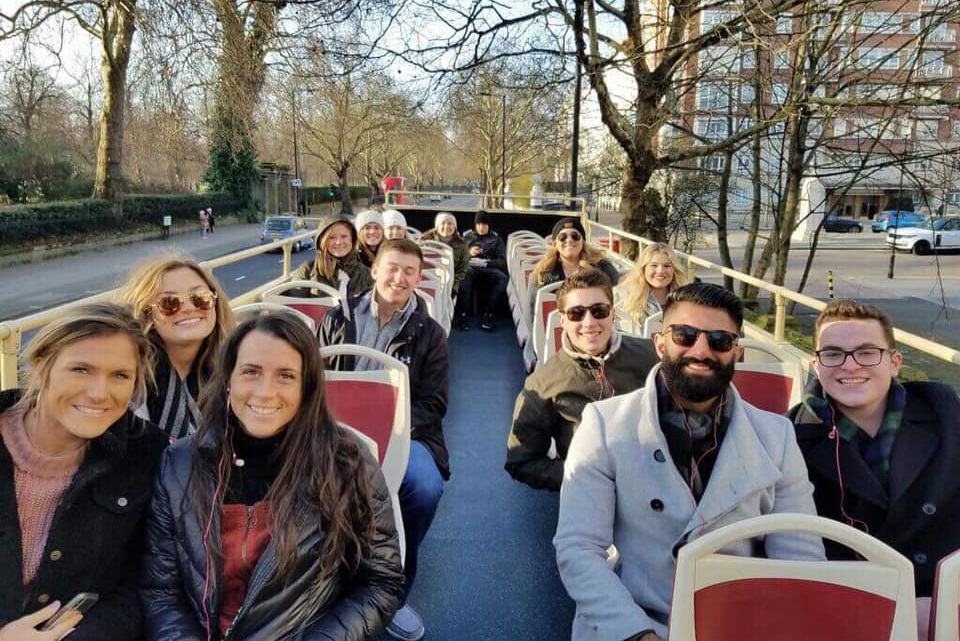 Study abroad students on a double decker tour bus