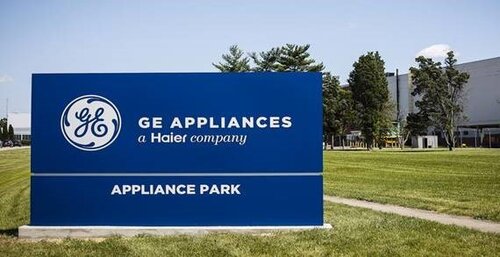 Sign reading "GE Appliances, a Haier company, Appliance Park" in front of a grassy area with trees and a building in the background.