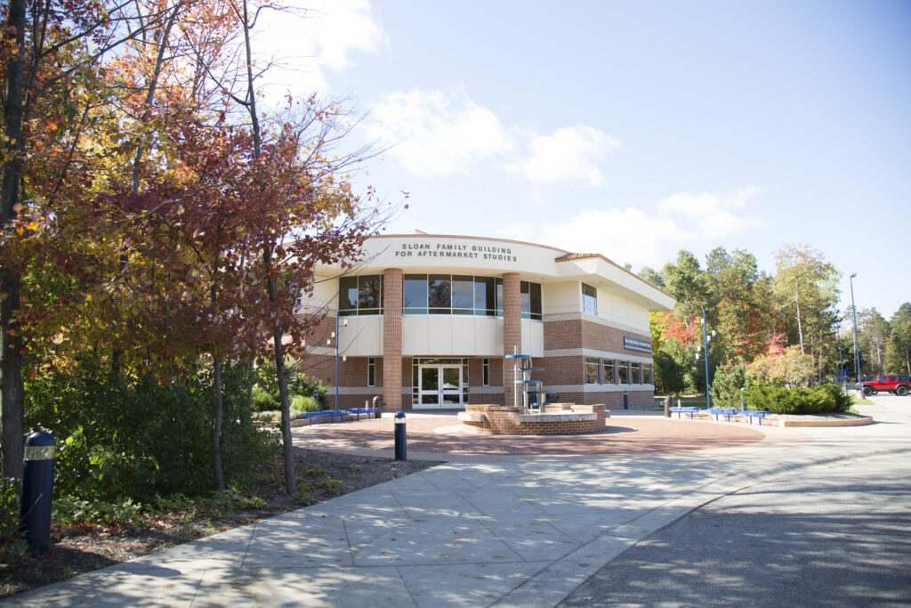 A two-story brick building with "Sloan Family Building for Aftermath Studies" on the facade, surrounded by autumn trees and a clear sky—an inviting spot on one of the best college campuses.
